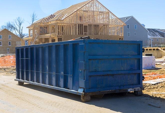 a rural residential area with a dumpster located at the end of a long driveway